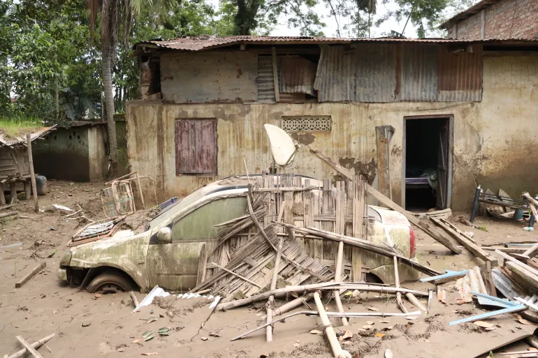 A car bogged down in silt in front of home affected by floodwater in Sivasagar Assam Arshad Ahmed Al Jazeera 1787307390